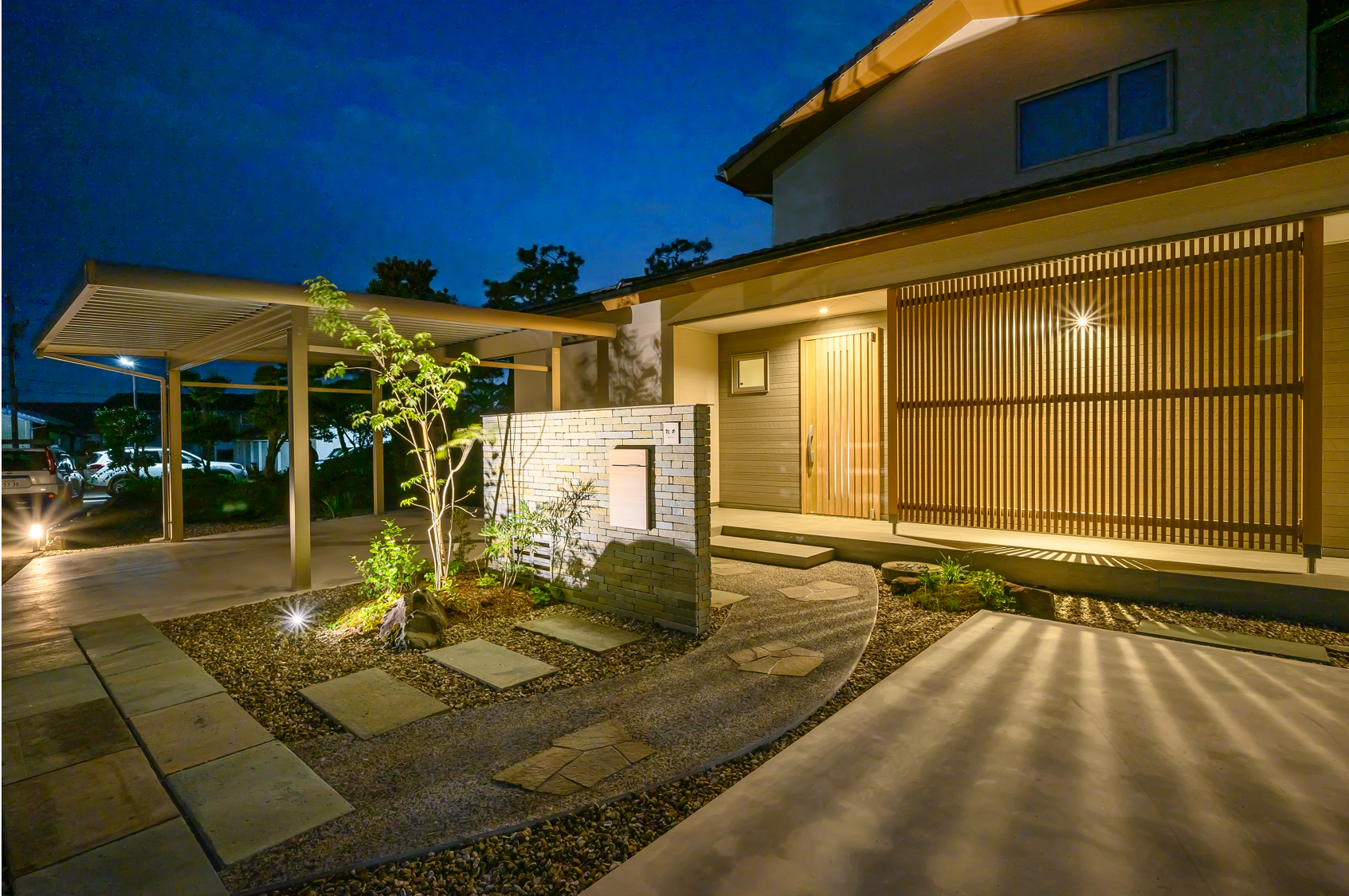 門柱や植栽を照らす灯りに、建物の格子の陰影が作り出す柔らかな光の線が美しくマッチしたライトアップ。